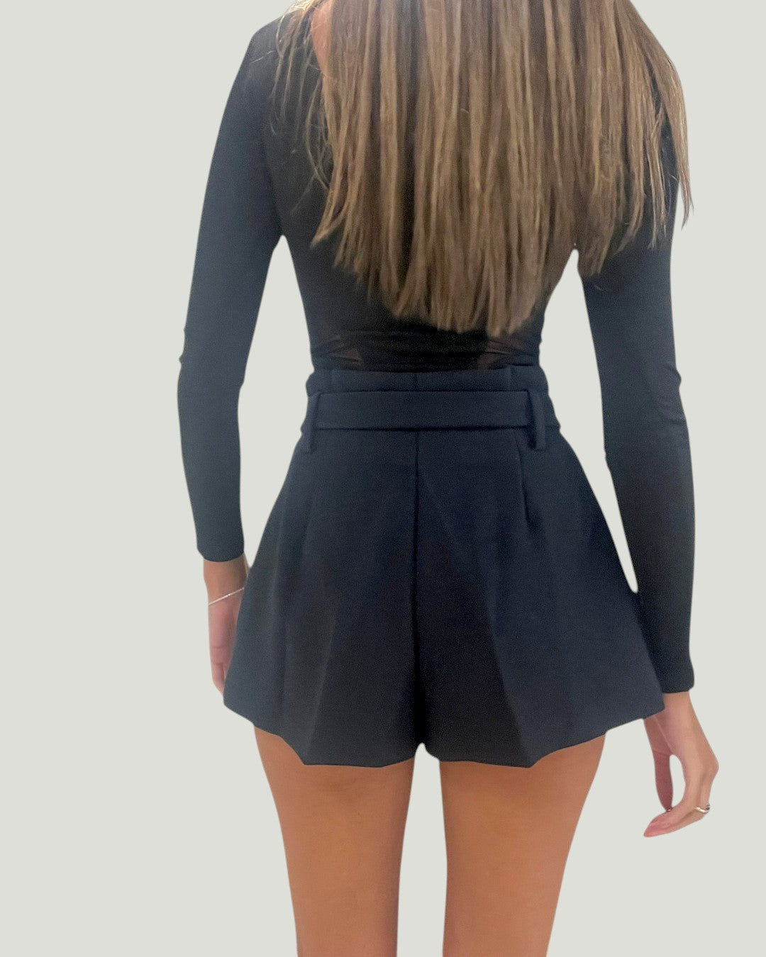 Achterkant van de zwarte Mademoiselle Ambitious Jeanne short met hoge taille en riemlussen op een model.