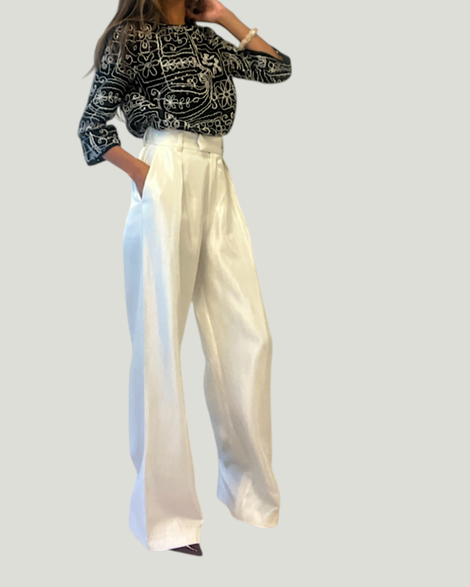 Mademoiselle Ambitious witte satijnen wide-leg broek met hoge taille en plooien, gedragen door een model.
